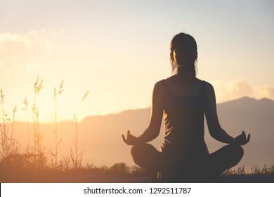 Silhouette Fitness Girl Practicing Yoga On Mountain With Sun Light