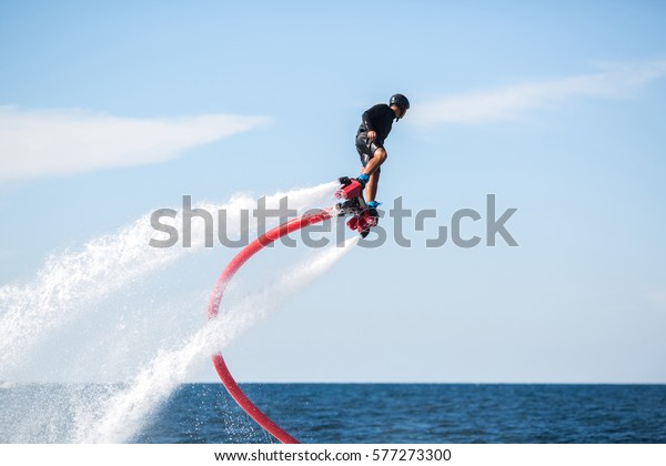 Silhouette of a fly board\
rider at sea