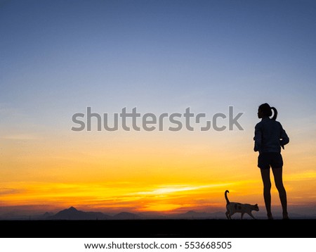 Silhouette of free woman and cat enjoying freedom feeling happy at sunset. Serene relaxing woman in pure happiness