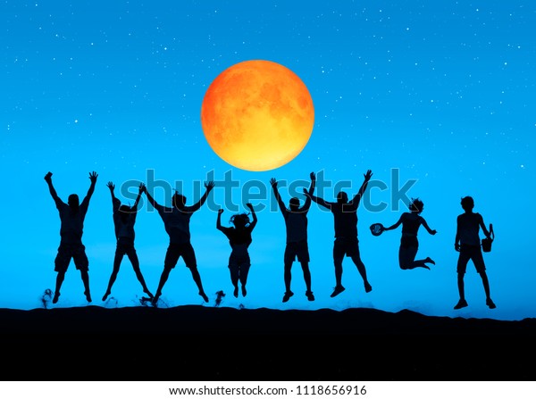Silhouette of friends jumping at\
Lunar Eclipse \