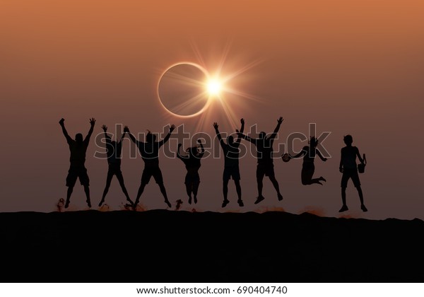 Silhouette of friends jumping at\
Solar Eclipse \