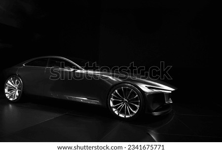 Silhouette of front black sports car with one LED headlights on black background,copy space	