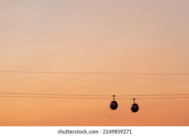 Silhouette of the funicular against the orange sunset sky