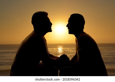 Silhouette Of Gay Couple Smiling On Sunset At The Beach