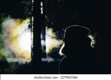 Silhouette Of A Girl Exhaling Cold Breath In Forest Winter