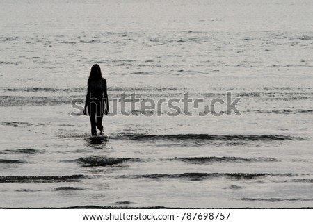 Silhouette of a girl standing on the beach while waiting for the sunset during her holiday at krabi, thailand
