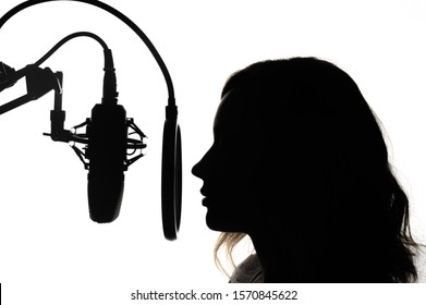 Silhouette of a girl with a studio microphone, radio presenter, singer and blogger, voice acting for films. Strong, black and white photo