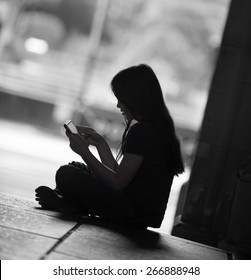 Silhouette Of A Girl Using Her Tablet Computer.  There May  Be A Predator Trying To Get To Her.