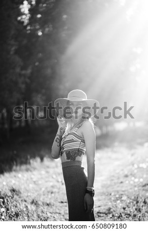 Similar – Image, Stock Photo Blonde woman with hat taking a walk in the forest at sunset with the sun in the background.