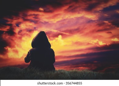 Silhouette of a girl watching the clouds after sunset.