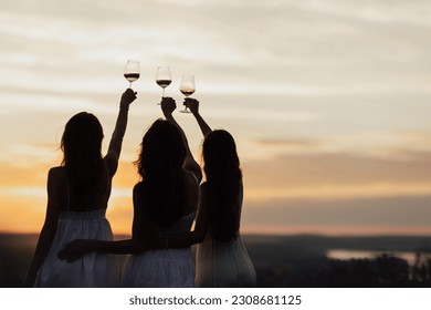 Silhouette of girlfriends enjoying their time together on a picnic at amazing sunset. Leisure and free time. Copy space.	
 - Shutterstock ID 2308681125