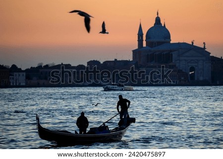 A Silhouette of Gondoliers on a Gondola on Canal San Marco in evening light in Venice, Italy.