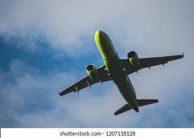 Silhouette Of A Green Plane Taking Off Against A Blue Sky