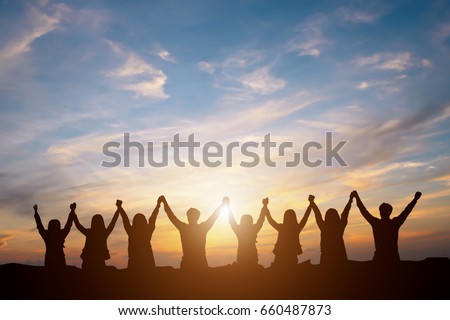 Silhouette of group happy business team making high hands over head in beautiful sunset sky evening time for business success and teamwork concept in company 