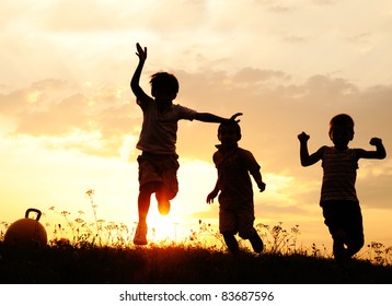 Silhouette, group of happy children playing on meadow, sunset, summertime - Shutterstock ID 83687596