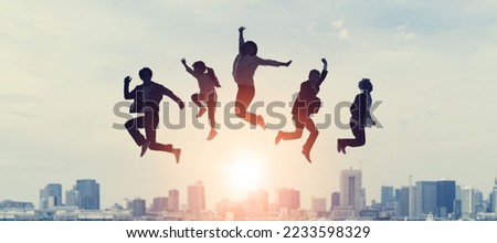 Silhouette of group of people jumping in front of city. Happy people. Family.