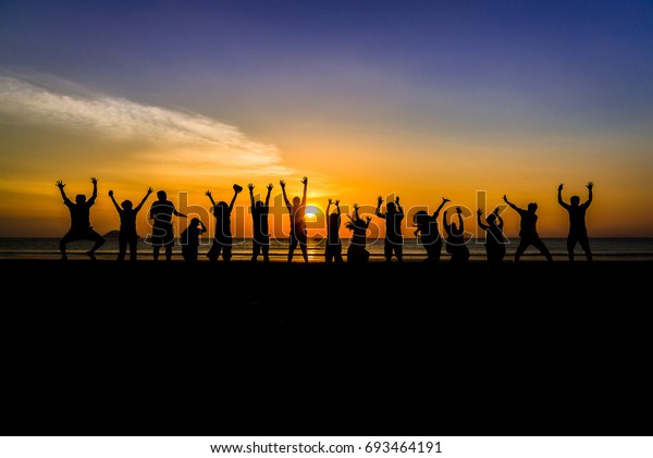 Silhouette Group People Jumping On Beach Stock Photo (Edit Now) 693464191