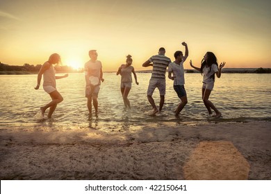 Silhouette Of Group Young People On The Beach.