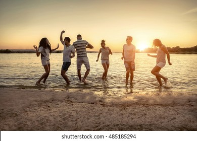 Silhouette Of Group Young People On The Beach.