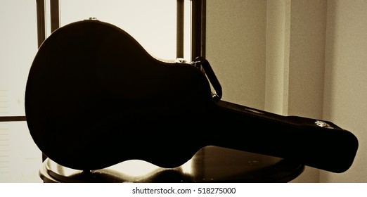 Silhouette Of A Guitar Case On The Table