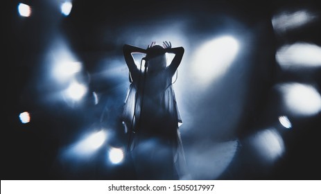 Silhouette of guitar player / guitarist / girl / woman perform on concert stage. Dark background, smoke, concert  spotlights - Powered by Shutterstock