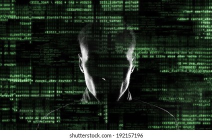 Silhouette of a hacker looking in camera with binary codes from monitor