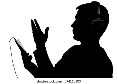 Silhouette Of Half Face Of Young Man With A Smart Phone Listening To Music With Big Headphones Old