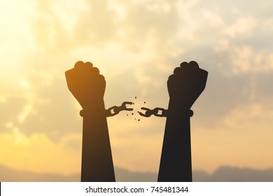 silhouette hand with chain is absent and blurred sky in sunrise background