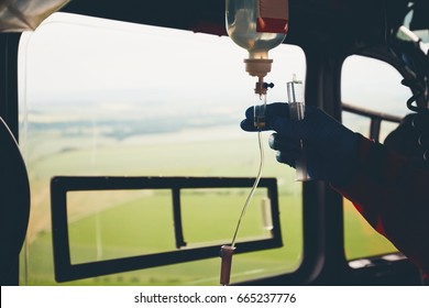 Silhouette of the hand of the doctor and infusion. Helicopter of the emergency medical service in flight. Czech Republic