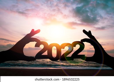 Silhouette Hand Holding 2022 Year On Beach Side. Preparation Happy New Year To Plan And Starting New Life And New Business Concept.