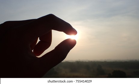 Silhouette Of A Hand Picking Sunlight In The Morning Success, Dream And Belief Concept