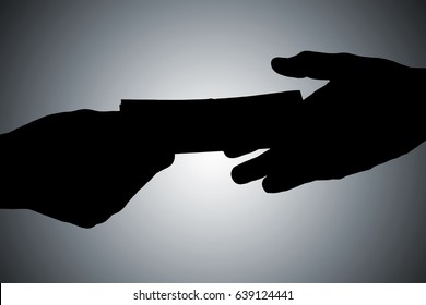 Silhouette Of Hands Giving Bribe Against Gray Background - Shutterstock ID 639124441