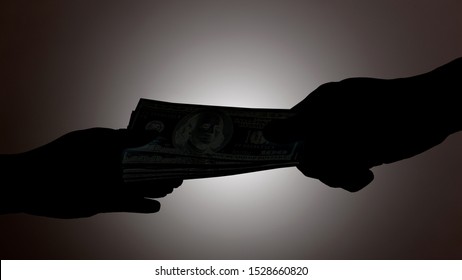 Silhouette Of Hands Giving Bribe With US Dollar Banknote Detail Gray Background