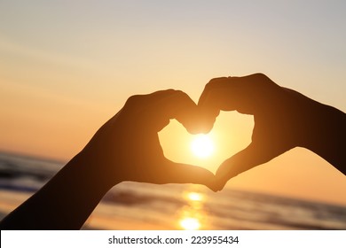 Silhouette Of Hands In Heart  Symbol Around The Sun