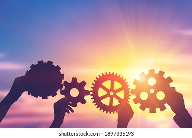 Silhouette hands holding gear from at sunlight background. concept of a teamwork cooperation idea.
 - Shutterstock ID 1897335193