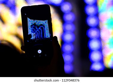 Silhouette of hands using camera phone to take pictures and videos at live concert, smartphone records live music festival.