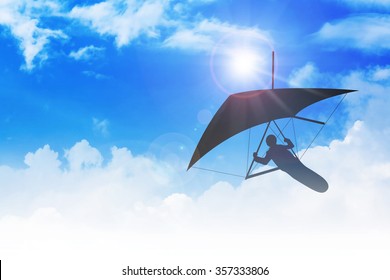 Silhouette Of Hang Glider Flying Among Clouds