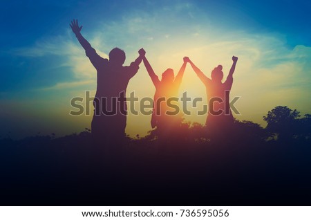 Silhouette of happiness teamwork hold hands up as a business successful, achieve business goal