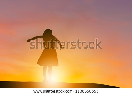 Silhouette of happy beautiful child little girl with clipping path sunset background with copy space