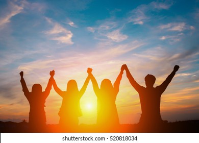 Silhouette Of Happy Business Team Making High Hands In Sunset Sky Background For Business Teamwork Concept