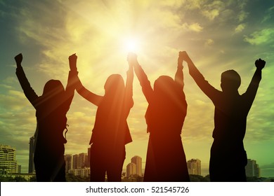 Silhouette Of Happy Business Team Making High Hands In City Background For Business Teamwork Concept