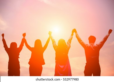 Silhouette Of Happy Business Team Making High Hands In Sunset Sky Background For Business Teamwork Concept