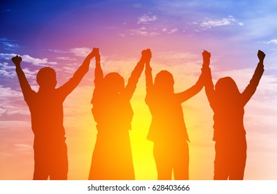 Silhouette Of Happy Business Team Making High Hands In Sunset Sky Background For Business Teamwork Concept.