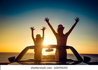 Silhouette Of Happy Family At The Beach Against Sunset Sky And Sea Background. People Traveling By Car. Summer Vacation And Travel Concept