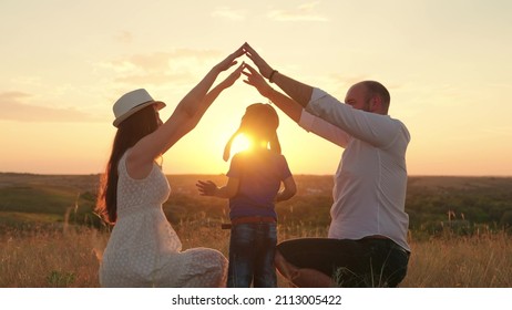 Silhouette Of Happy Family Playing Shows Symbol Of Comfortable Home With Their Hands At Sunset. Teamwork Happy Family Father Mother Child Son Dream To Buy House. Mortgage Lending Concept, Family Home