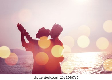 Silhouette Happy Mature couple  happy retirement planning concept, Beautiful and happy senior couple in love and enjoying retirement celebrating walking on the beach with flare and bokeh light. - Powered by Shutterstock