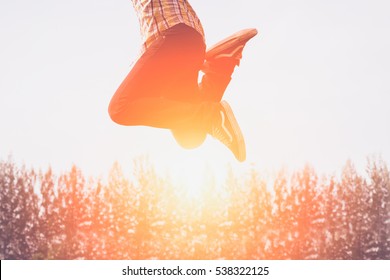 Silhouette Of Happy People Jumping In Sunset.