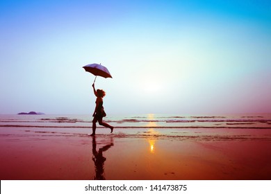 silhouette of happy running woman with umbrella - Powered by Shutterstock