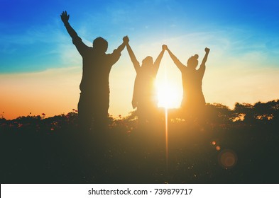 Silhouette of happy success positive teamwork hold hands up as business successful, business victory & celebrate achievement. Accomplish people merger & acquisitions concept. - Shutterstock ID 739879717