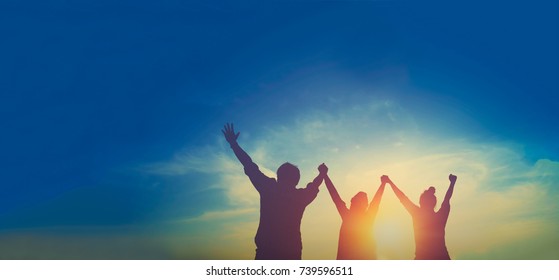 Silhouette of happy teamwork hold hands up as a business successful, business victory, achieve business goal